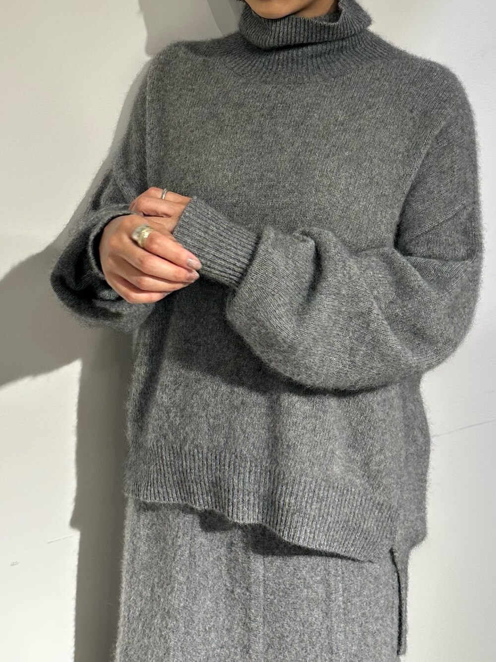 パープル系のノーカラージャケット、グレー系のスカート、ブラック系のブーツを着用したレディースの秋コーディネートの8枚目の写真