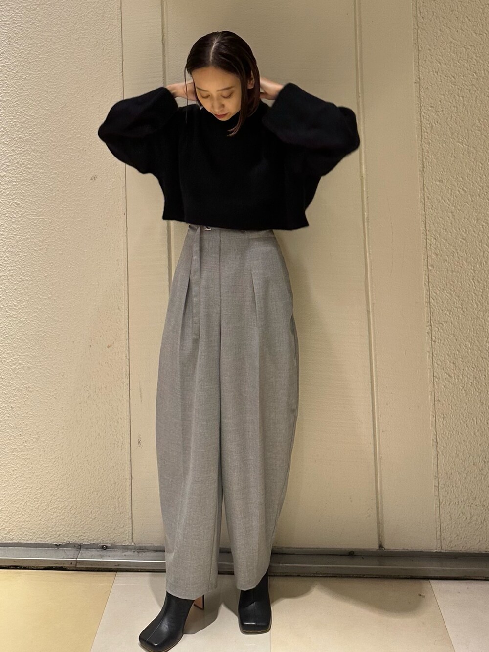 ブラック系のニット/セーター、グレー系のその他パンツ、ブラック系のブーツを着用したレディースの冬コーディネートの3枚目の写真