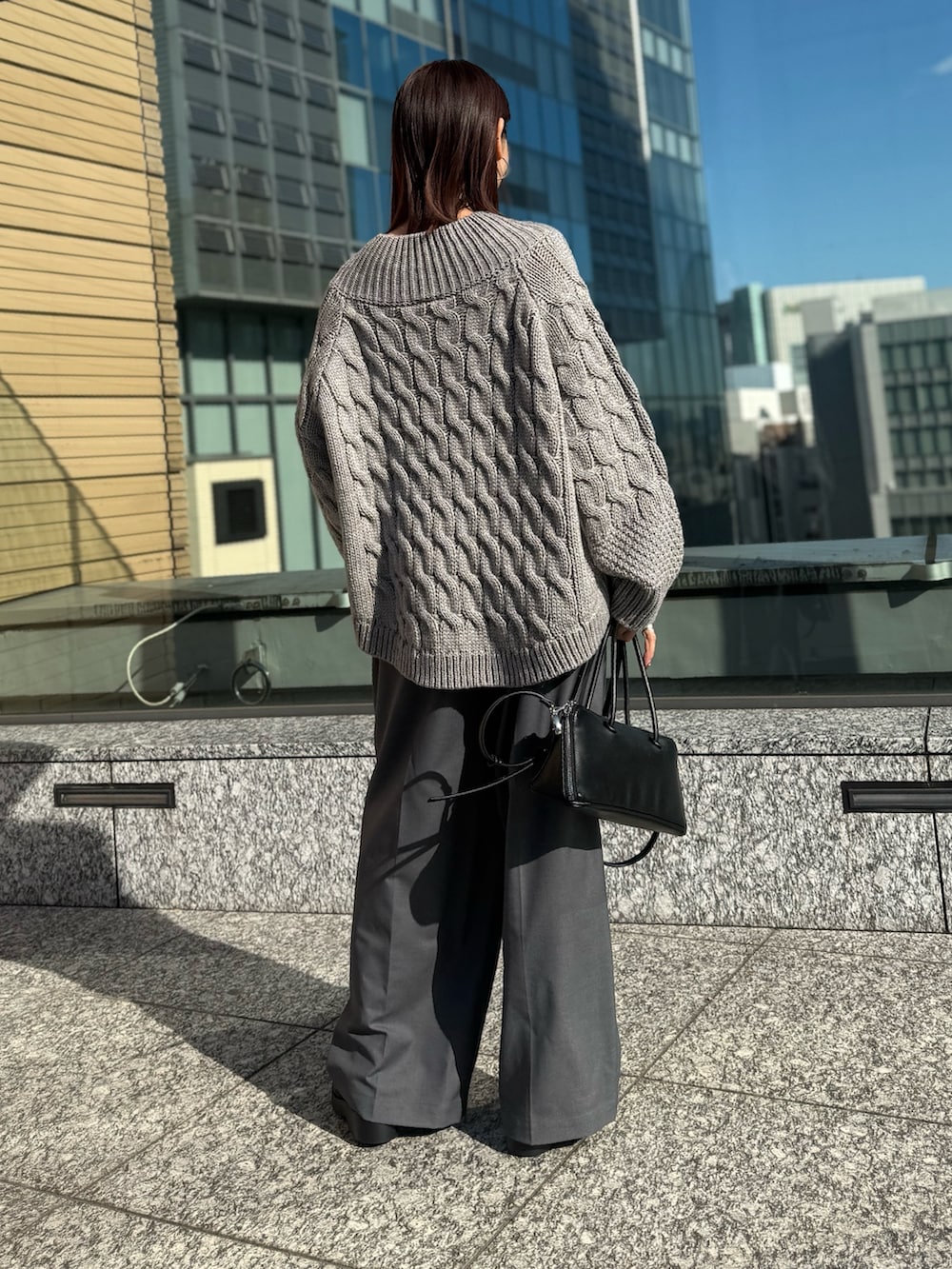 グレー系のその他パンツ、グレー系のニット/セーター、ブラック系のローファーを着用したレディースの冬コーディネートの3枚目の写真