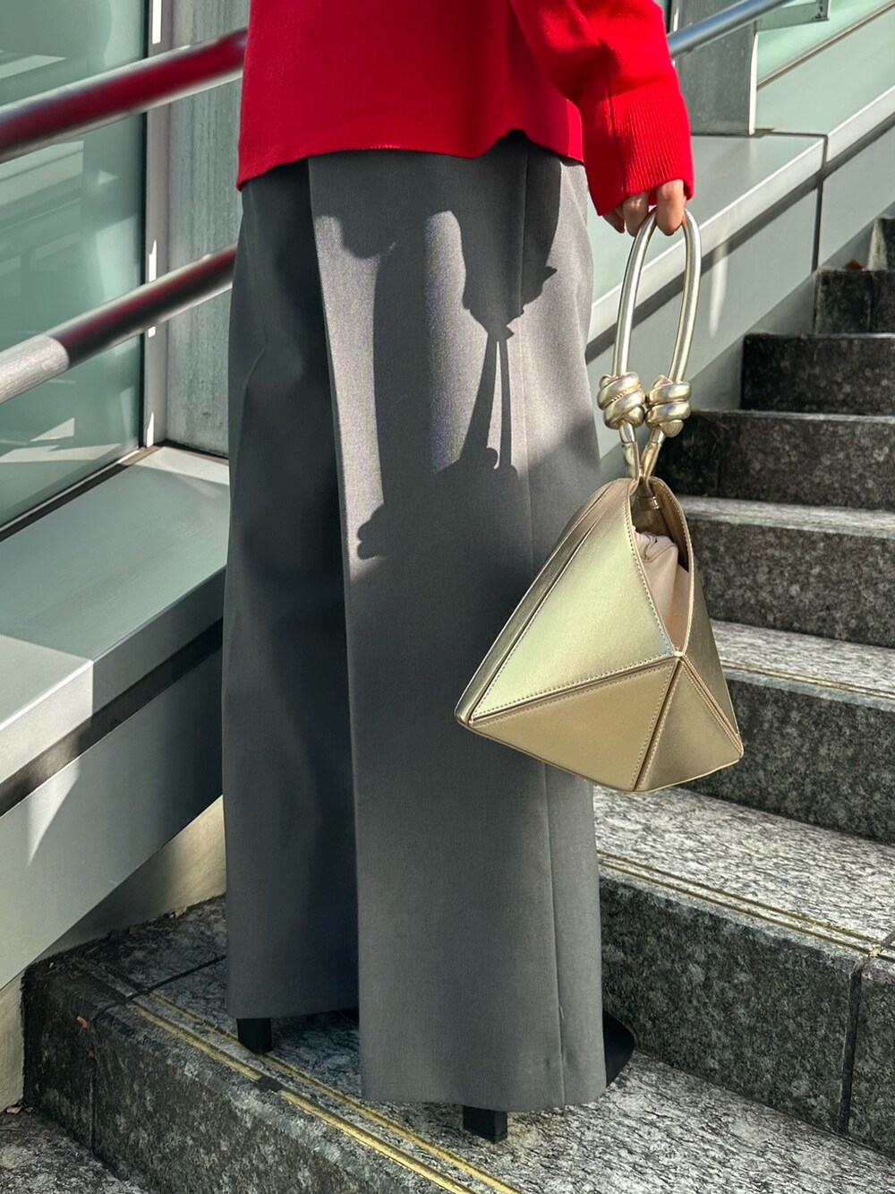 ブラック系のブーツ、グレー系のノーカラージャケット、レッド系のニット/セーターを着用したレディースの冬コーディネートの7枚目の写真