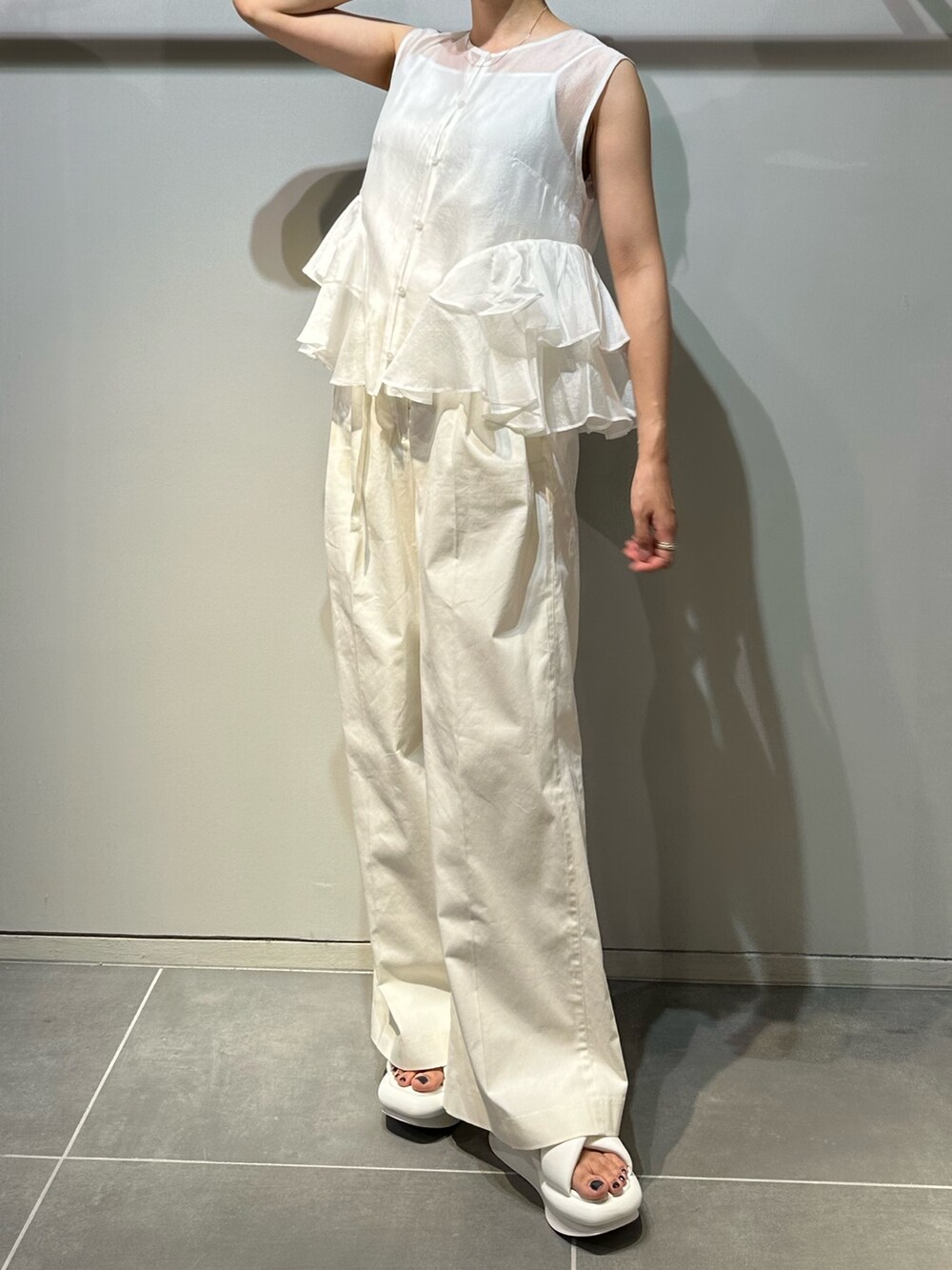 ホワイト系のサンダル、ホワイト系のその他パンツ、ホワイト系のシャツ/ブラウスを着用したレディースの春コーディネートの2枚目の写真