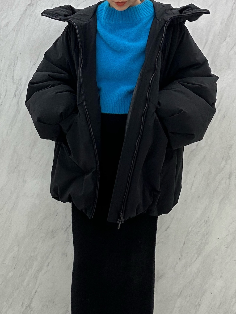 ブラック系のブーツ、ブラック系のスカート、ブラック系のダウンジャケット/コートを着用したレディースの秋コーディネートの5枚目の写真