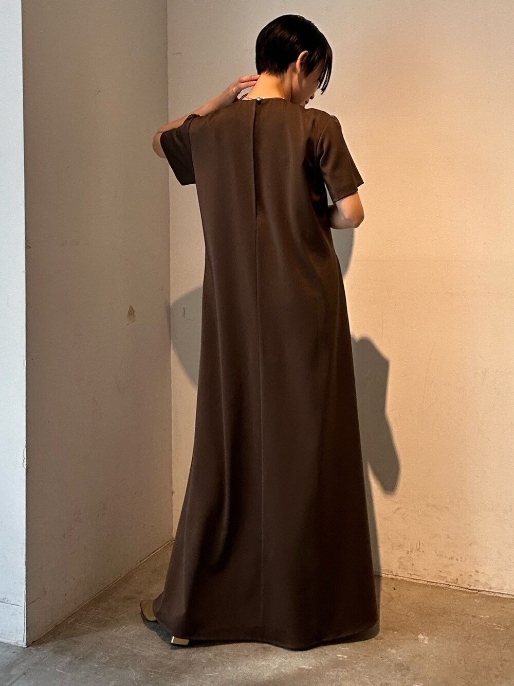 ブラウン系のワンピース、ゴールド系のパンプスを着用したレディースの春コーディネートの7枚目の写真