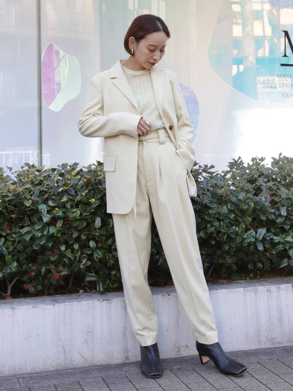 イエロー系のテーラードジャケット、イエロー系のその他パンツ、ブラック系のブーツを着用したレディースの冬コーディネートの2枚目の写真