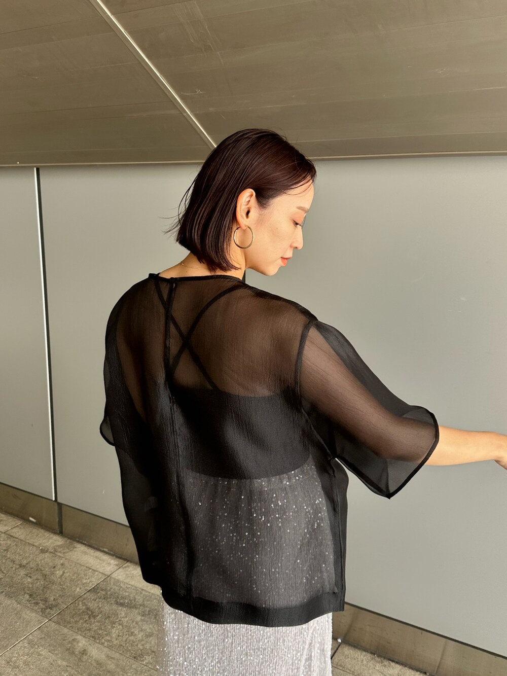 ブラック系のシャツ/ブラウス、シルバー系のスカートを着用したレディースの夏コーディネートの5枚目の写真