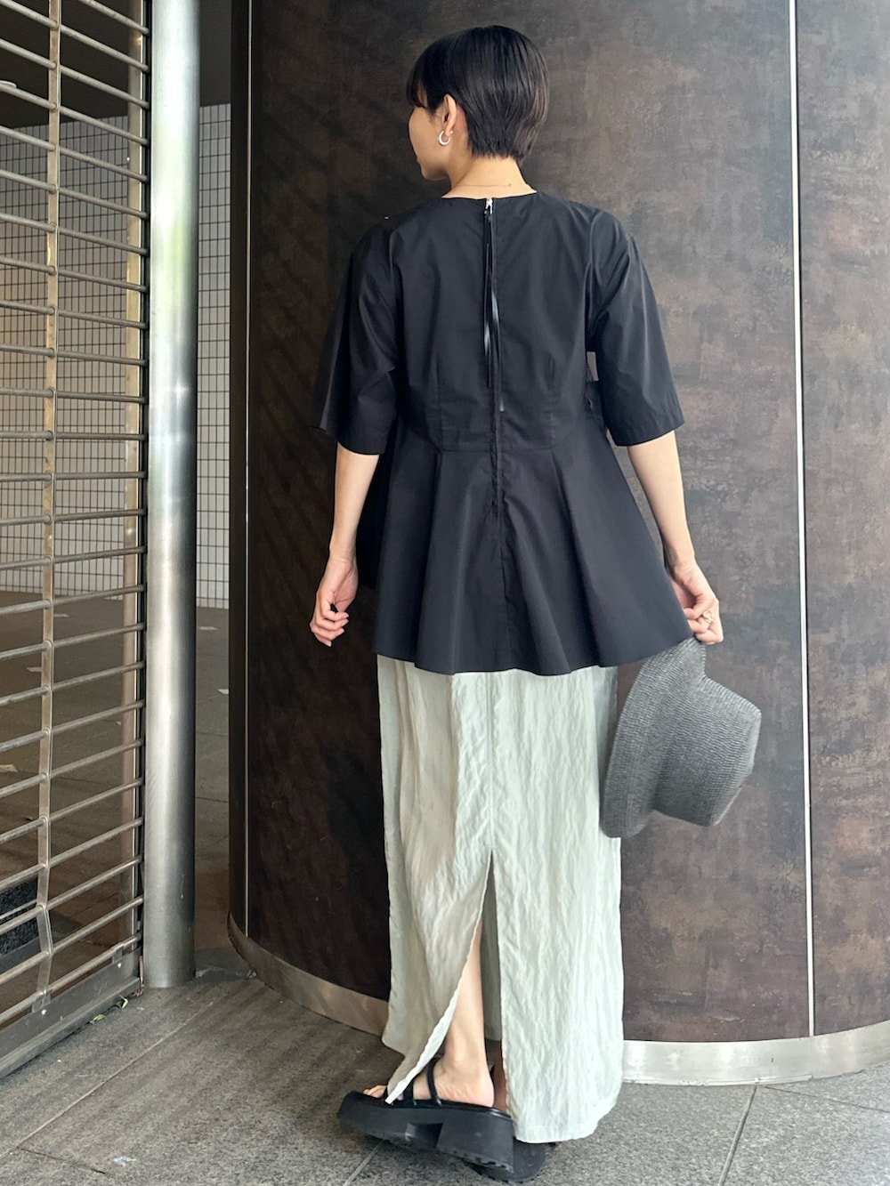 ブラック系のシャツ/ブラウス、グリーン系のスカート、ブラック系のサンダルを着用したレディースの夏コーディネートの4枚目の写真