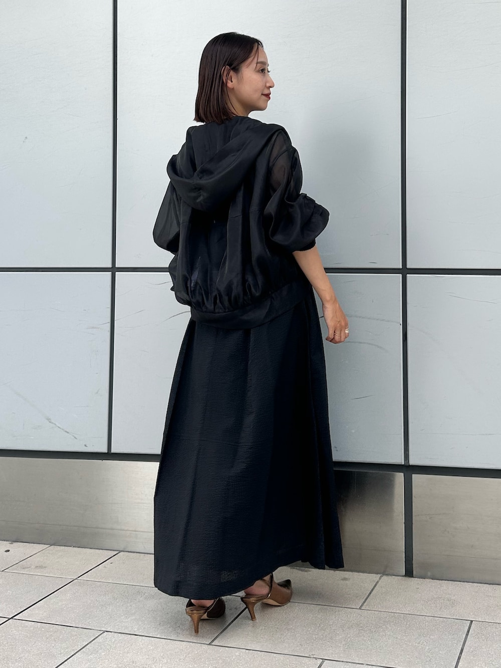 ブラック系のワンピース、その他のパンプス、ブラック系のブルゾンを着用したレディースの夏コーディネートの4枚目の写真