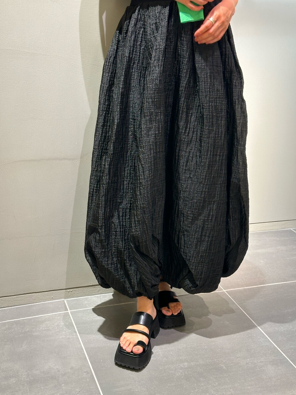 ブラック系のワンピース、ブラック系のサンダル、グリーン系のカーディガン/ボレロを着用したレディースの夏コーディネートの8枚目の写真