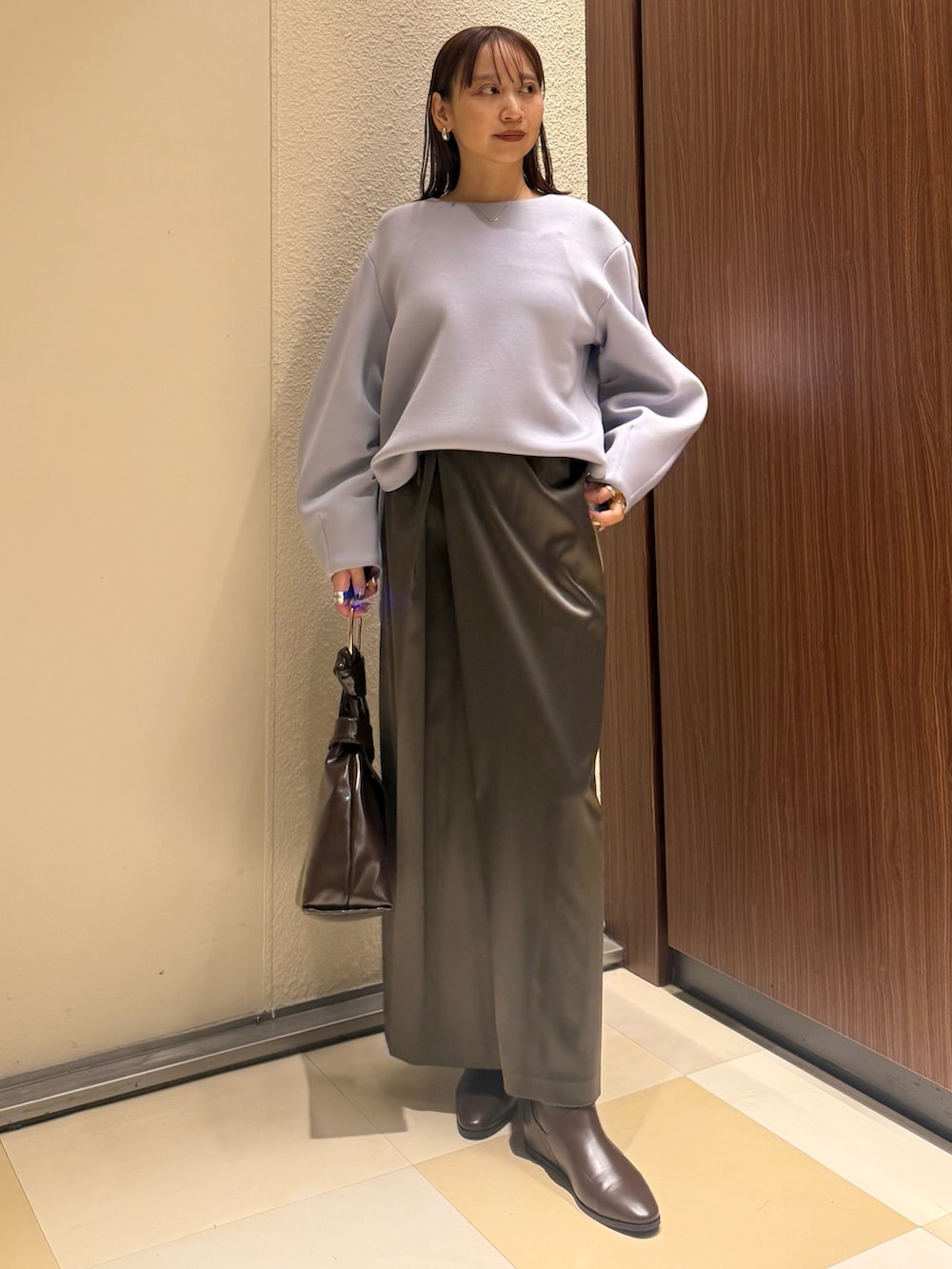 ブルー系のTシャツ/カットソー、ブラウン系のスカート、ブラウン系のブーツを着用したレディースの冬コーディネートの2枚目の写真