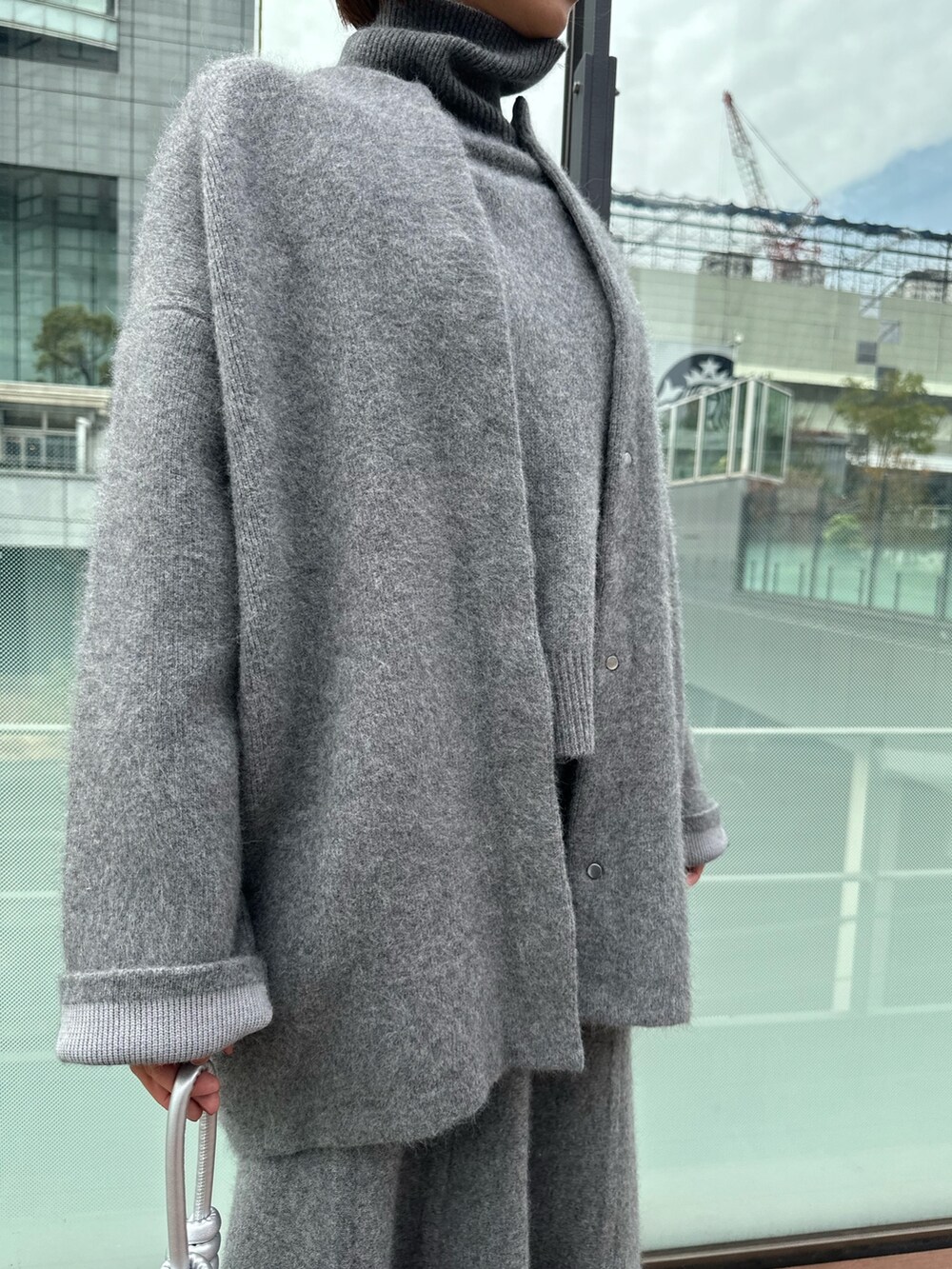 グレー系のスカート、グレー系のノーカラージャケット、グレー系のニット/セーターを着用したレディースの冬コーディネートの7枚目の写真