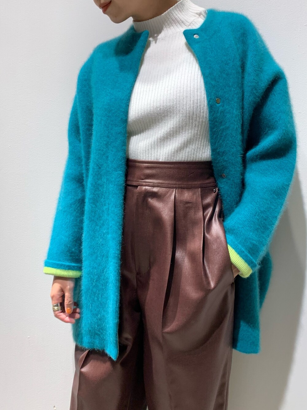 グリーン系のカーディガン/ボレロ、ブラウン系のその他パンツ、ブラック系のブーツを着用したレディースの秋コーディネートの3枚目の写真