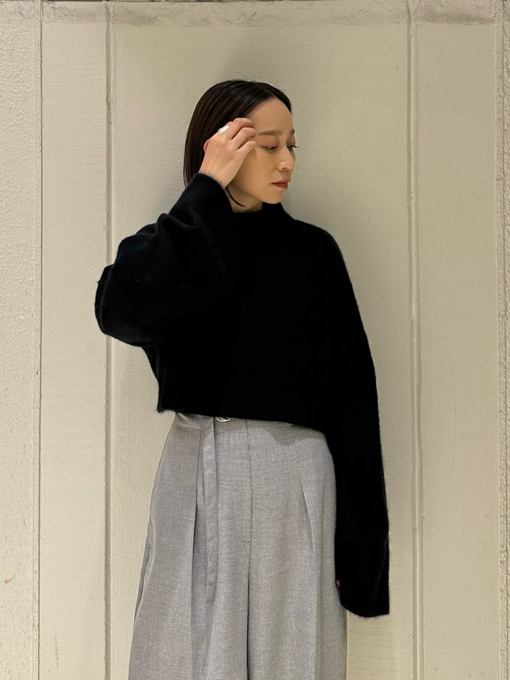 ブラック系のニット/セーター、グレー系のその他パンツ、ブラック系のブーツを着用したレディースの冬コーディネートの6枚目の写真