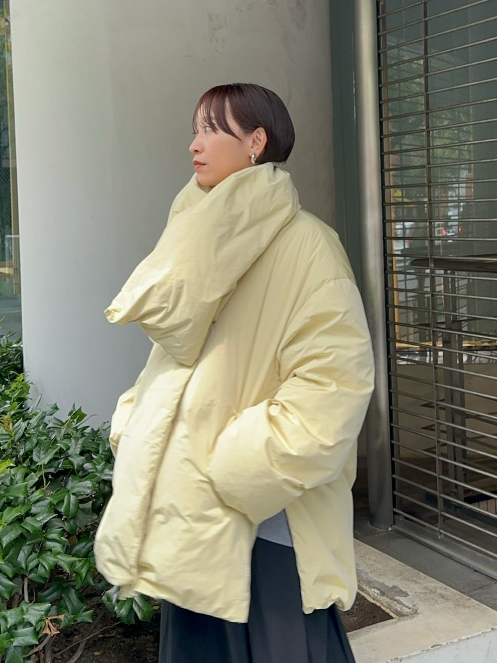 イエロー系のダウンジャケット/コート、グレー系のワンピース、ブラック系のブーツを着用したレディースの夏コーディネートの4枚目の写真