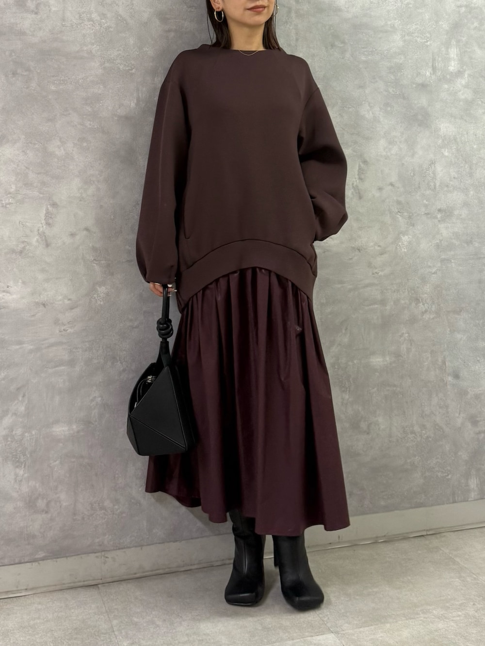 ブラウン系のワンピース、ブラック系のハンドバッグを着用したレディースの秋コーディネートの2枚目の写真