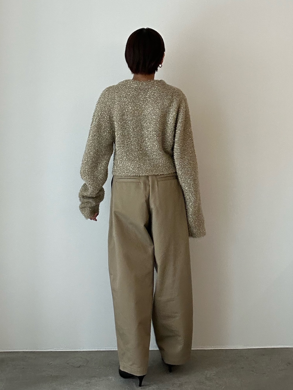 ゴールド系のカーディガン/ボレロ、ベージュ系のその他パンツ、ブラック系のサンダルを着用したレディースの冬コーディネートの5枚目の写真