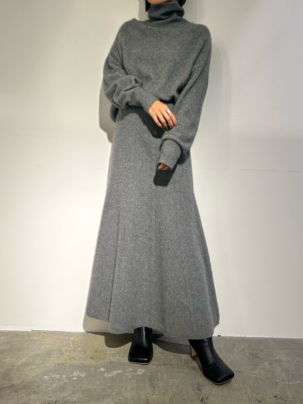 パープル系のノーカラージャケット、グレー系のスカート、ブラック系のブーツを着用したレディースの秋コーディネートの5枚目の写真