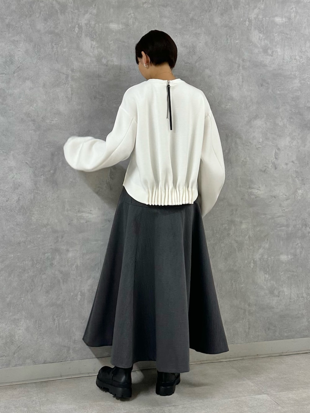 ホワイト系のTシャツ/カットソー、グレー系のスカートを着用したレディースの秋コーディネートの5枚目の写真