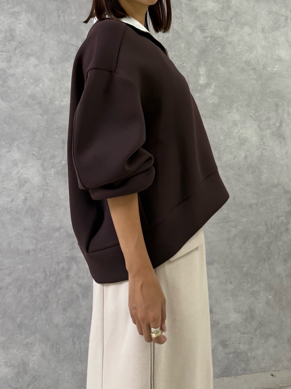 ブラウン系のTシャツ/カットソー、ホワイト系のスカート、ブラウン系のブーツを着用したレディースの秋コーディネートの5枚目の写真