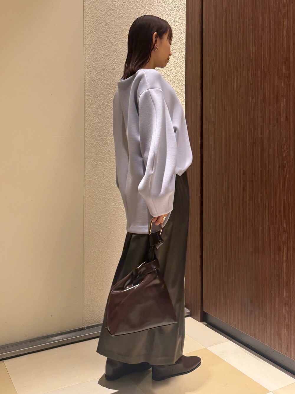 ブルー系のTシャツ/カットソー、ブラウン系のスカート、ブラウン系のブーツを着用したレディースの冬コーディネートの6枚目の写真