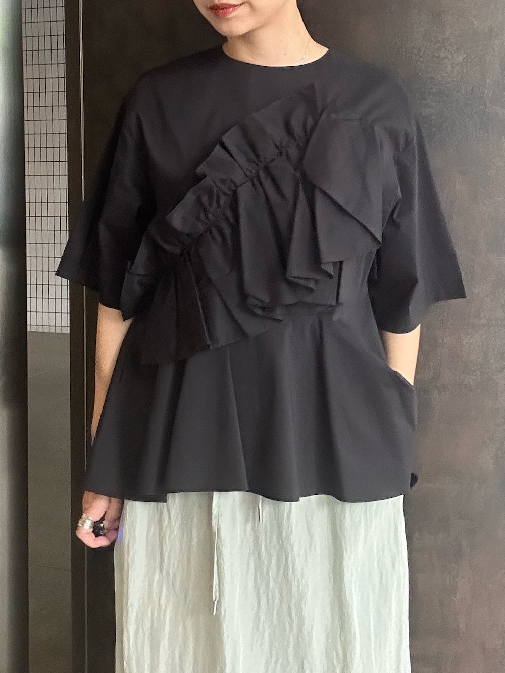 ブラック系のシャツ/ブラウス、グリーン系のスカート、ブラック系のサンダルを着用したレディースの夏コーディネートの6枚目の写真