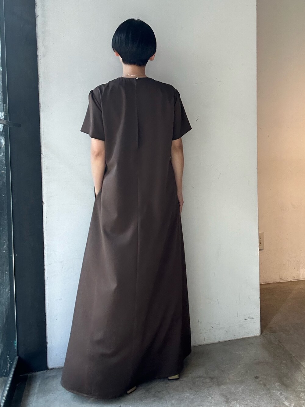 ブラウン系のワンピース、ゴールド系のパンプスを着用したレディースの春コーディネートの4枚目の写真