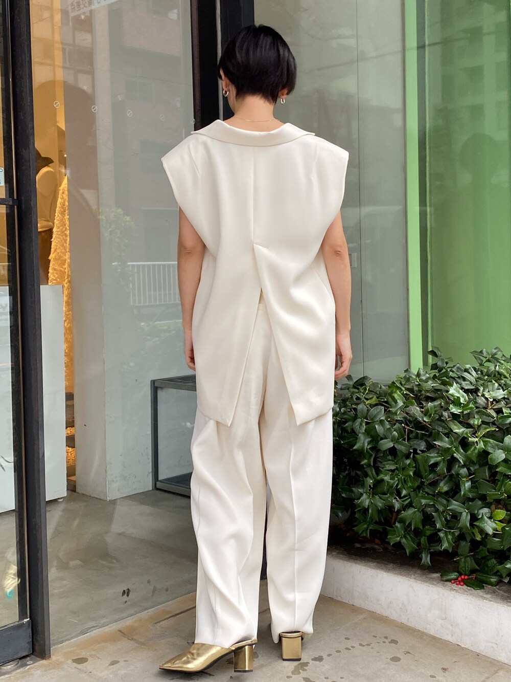 ホワイト系のテーラードジャケット、ゴールド系のパンプス、ホワイト系のその他パンツを着用したレディースの春コーディネートの3枚目の写真