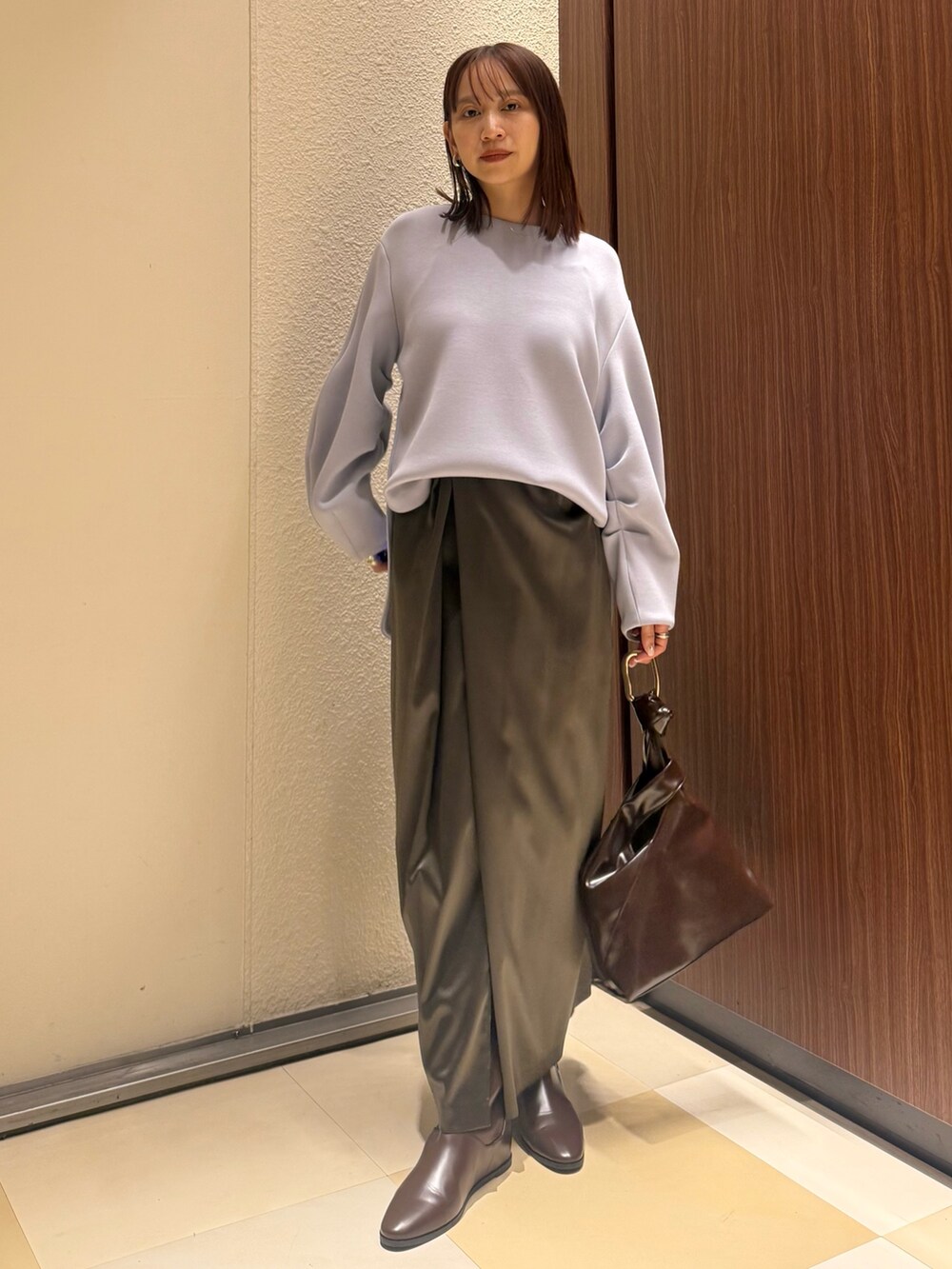 ブルー系のTシャツ/カットソー、ブラウン系のスカート、ブラウン系のブーツを着用したレディースの冬コーディネートの3枚目の写真