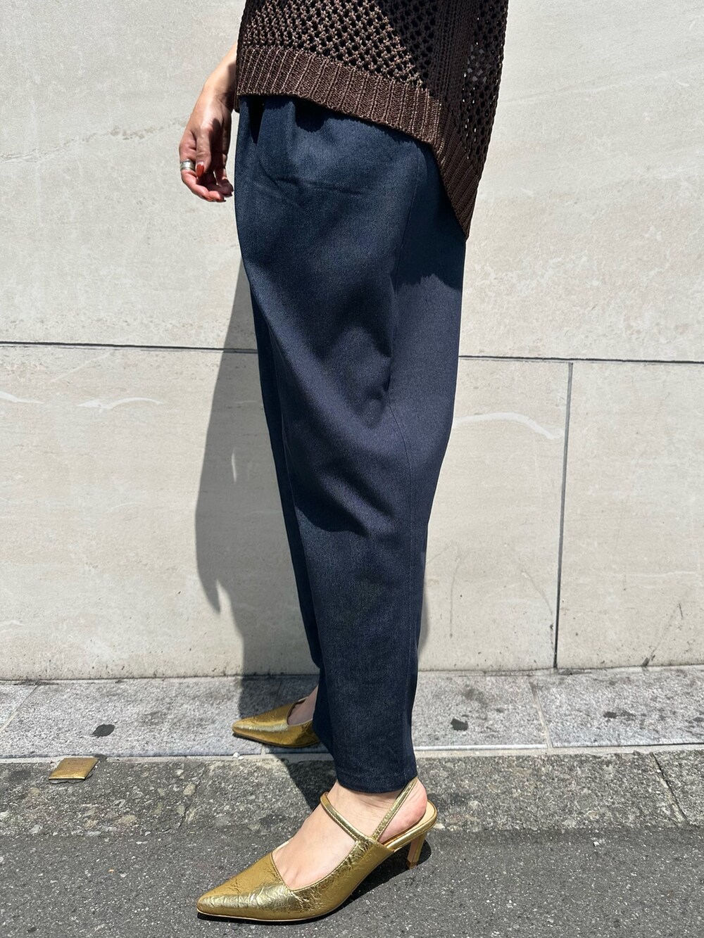 ブラウン系のニット/セーター、ブルー系のつなぎ/オールインワン、ゴールド系のサンダルを着用したレディースの春コーディネートの7枚目の写真