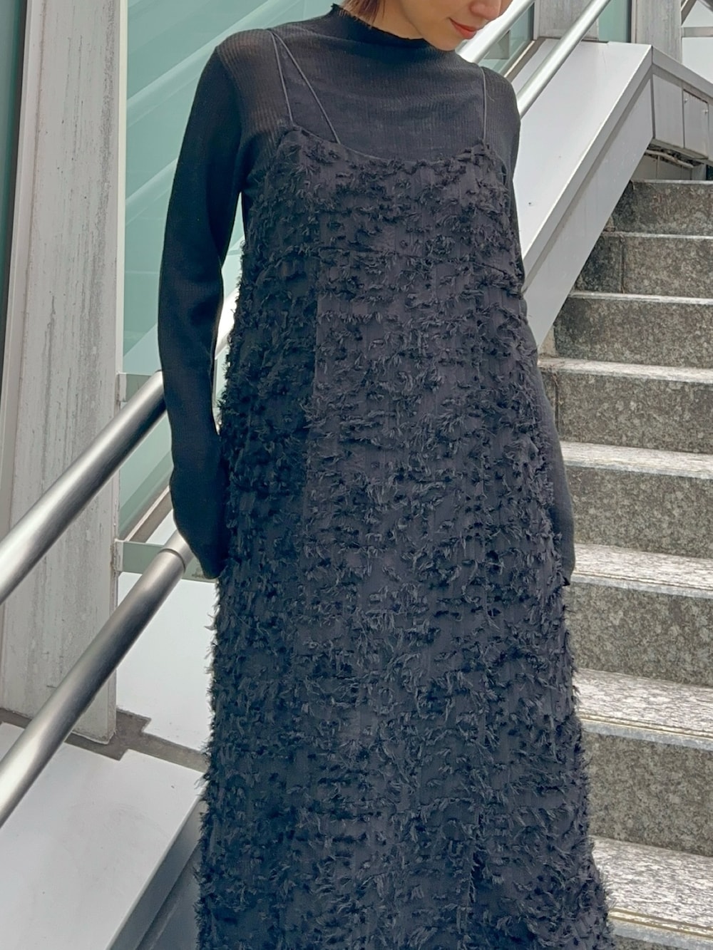 ブラック系のスニーカー、ブラック系のワンピース、ブラック系のニット/セーターを着用したレディースの冬コーディネートの3枚目の写真