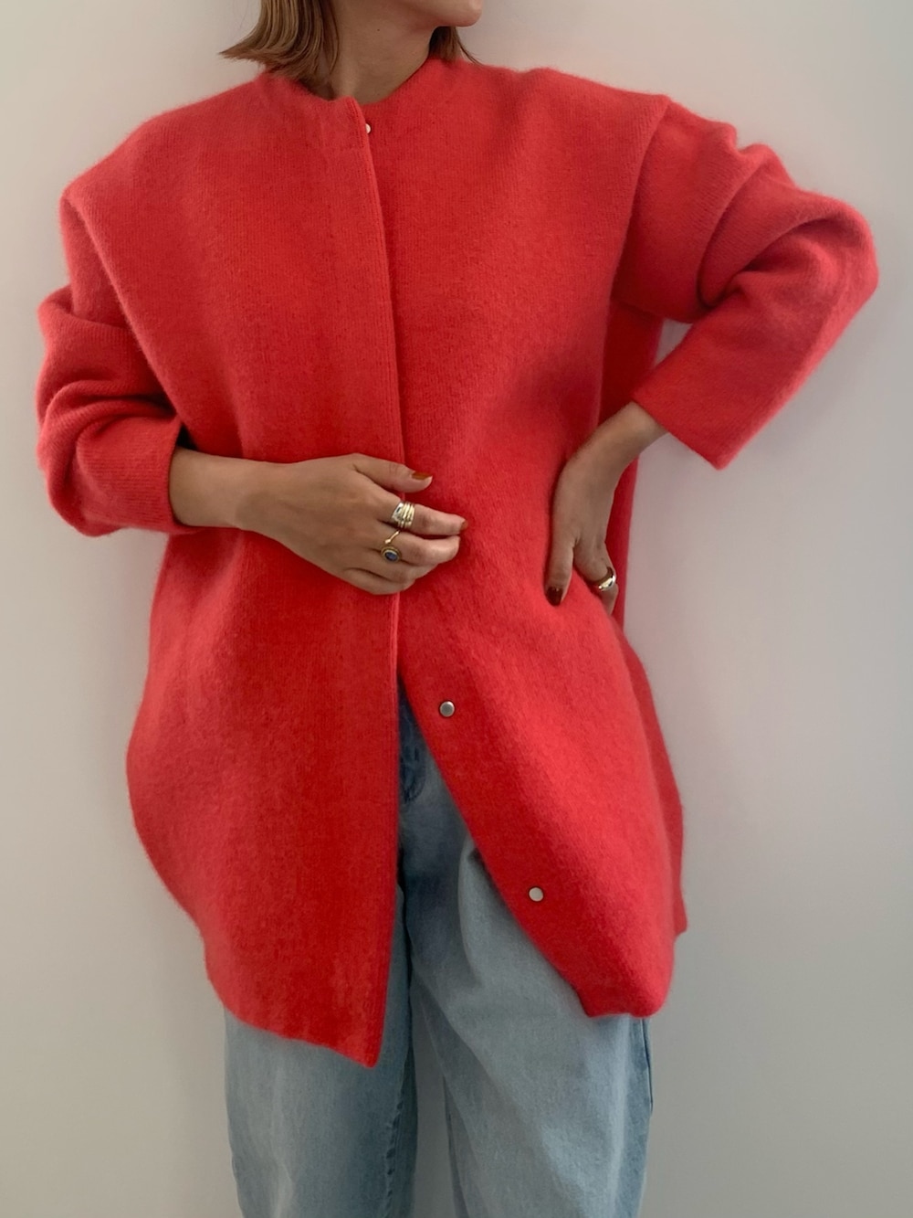 ブルー系のデニムパンツ、ブラック系のパンプス、ピンク系のノーカラージャケットを着用したレディースの夏コーディネートの4枚目の写真