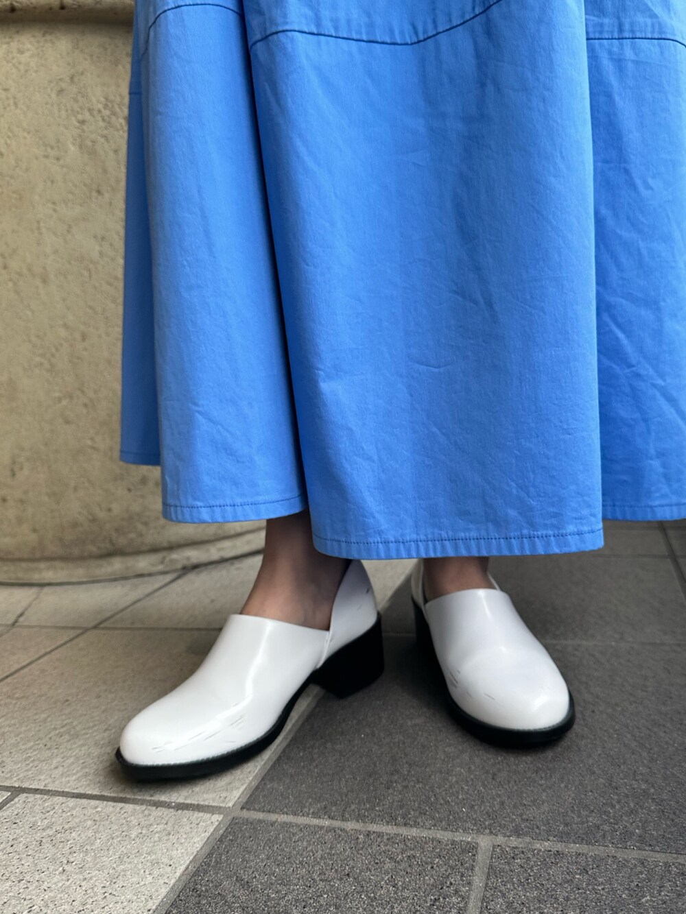ブルー系のシャツ/ブラウス、ブルー系のスカート、ホワイト系のパンプスを着用したレディースの夏コーディネートの10枚目の写真