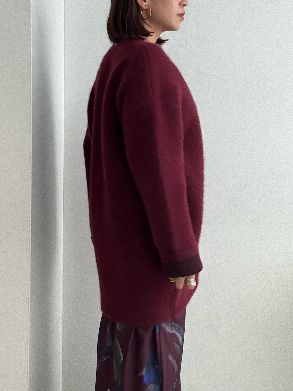 レッド系のスカート、レッド系のカーディガン/ボレロ、ブラック系のブーツを着用したレディースの夏コーディネートの6枚目の写真