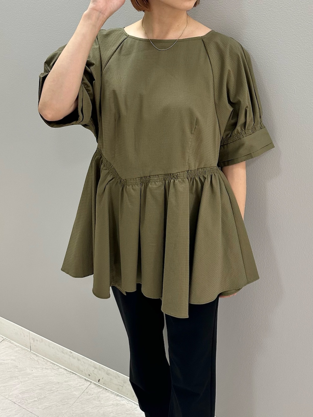 グリーン系のシャツ/ブラウス、ブラック系のスラックス、ブラック系のパンプスを着用したレディースの夏コーディネートの5枚目の写真