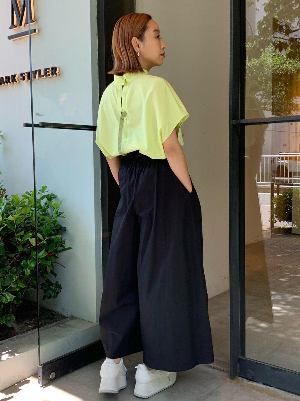 ブラック系のその他パンツ、ホワイト系のスニーカー、イエロー系のシャツ/ブラウスを着用したレディースの春コーディネートの3枚目の写真