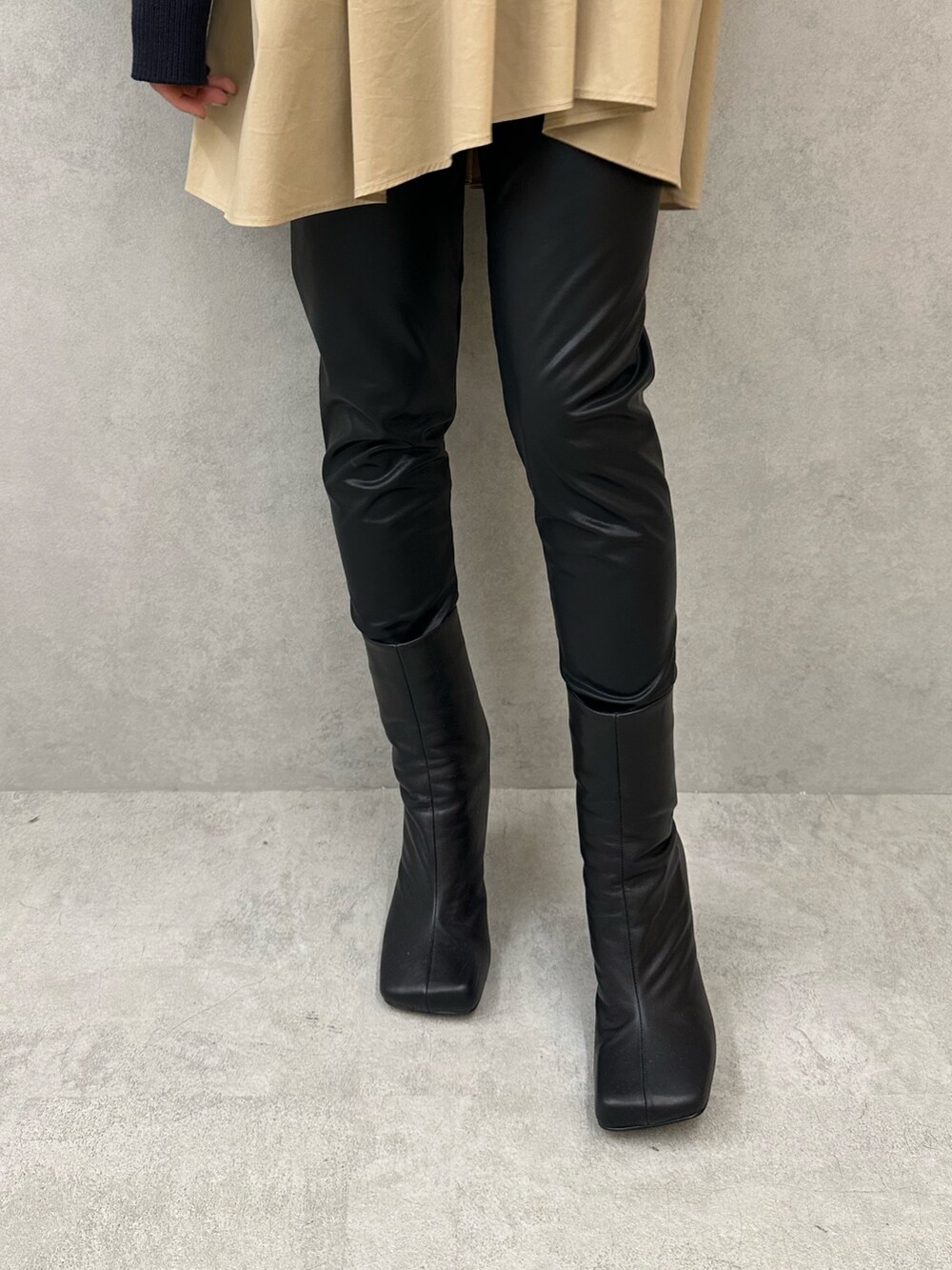 ブルー系のニット/セーター、ブラック系のその他パンツ、ブラック系のブーツを着用したレディースの秋コーディネートの8枚目の写真