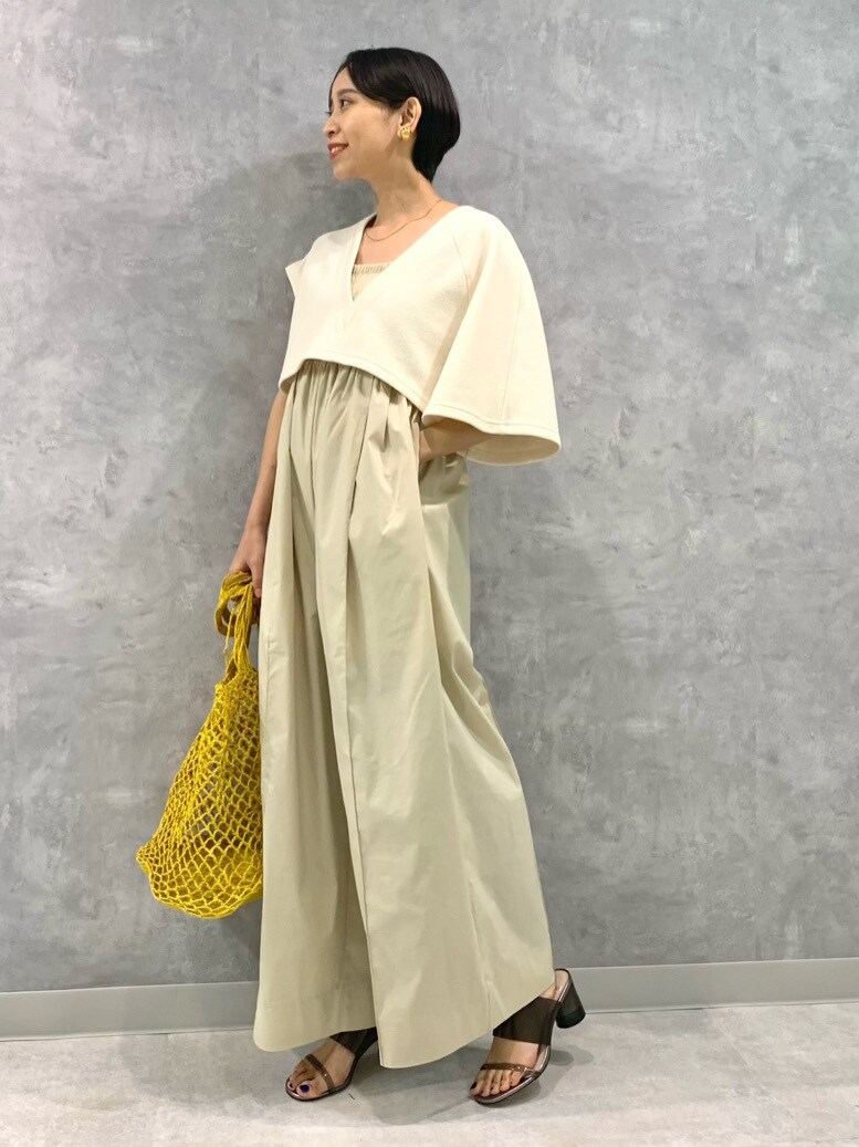 イエロー系のかごバッグを着用したレディースの春コーディネートの2枚目の写真