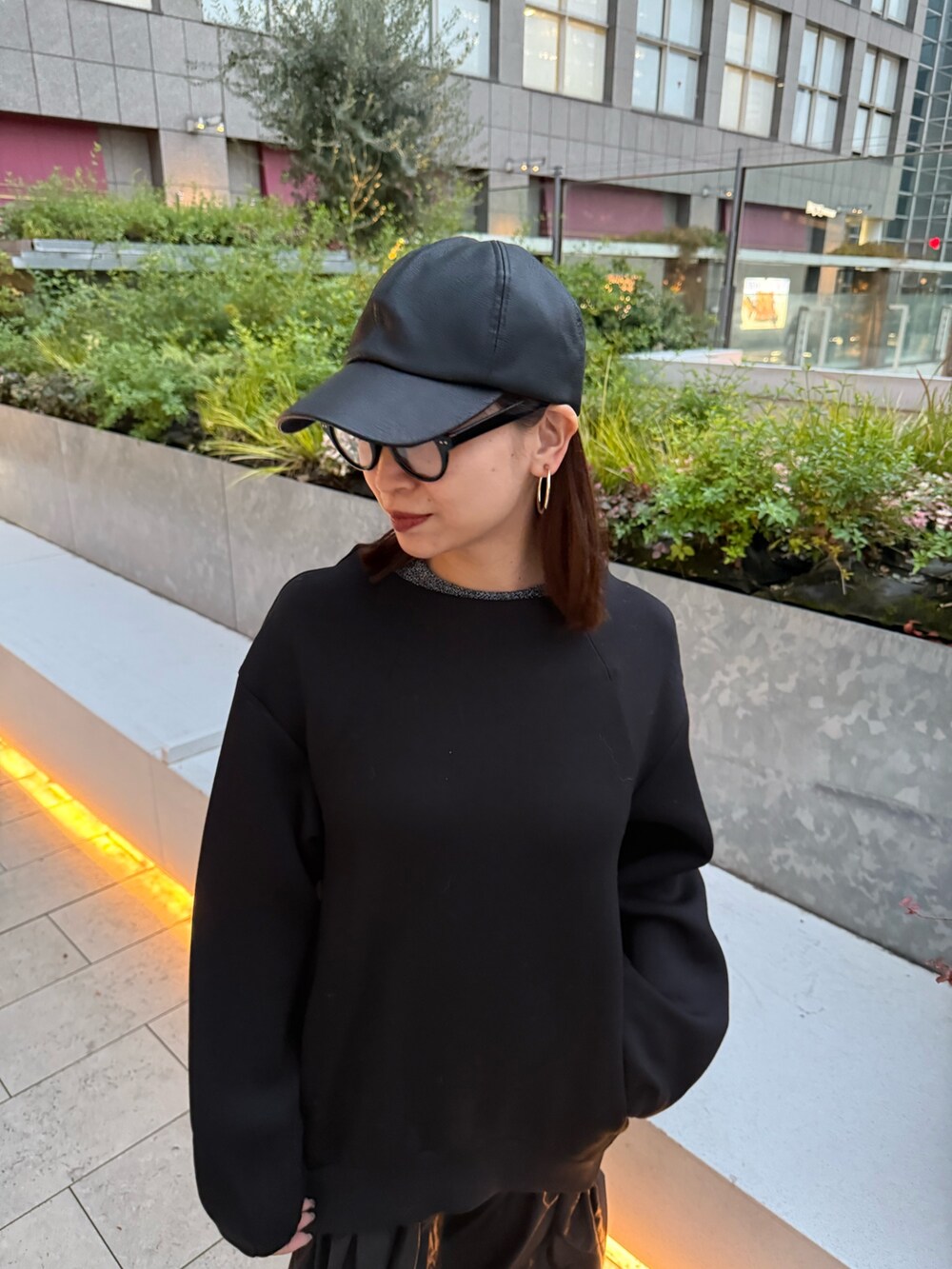 ブラック系のワンピース、ブラック系のブーツ、ブラック系のキャップを着用したレディースの冬コーディネートの3枚目の写真