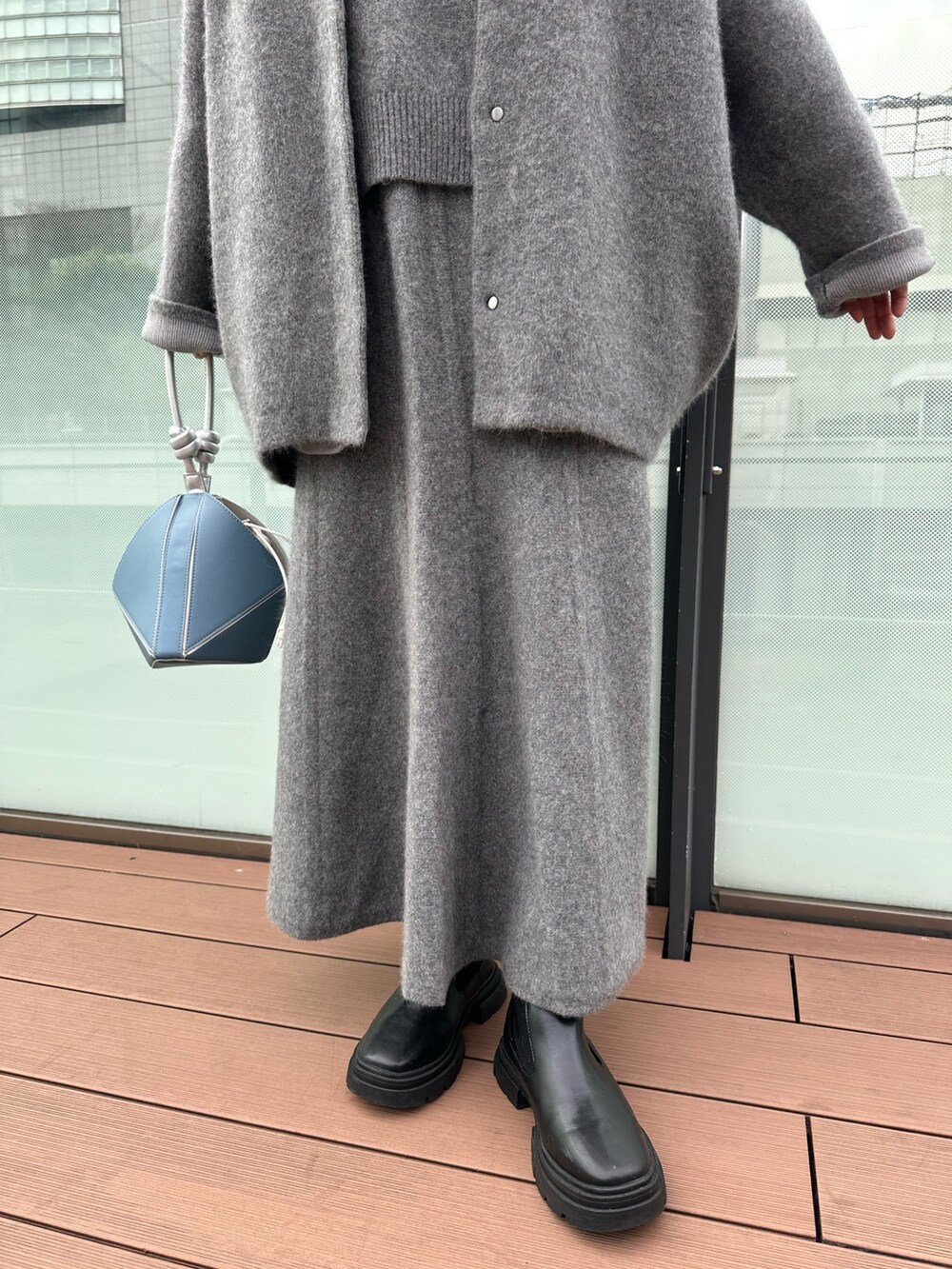 グレー系のスカート、グレー系のノーカラージャケット、グレー系のニット/セーターを着用したレディースの冬コーディネートの6枚目の写真