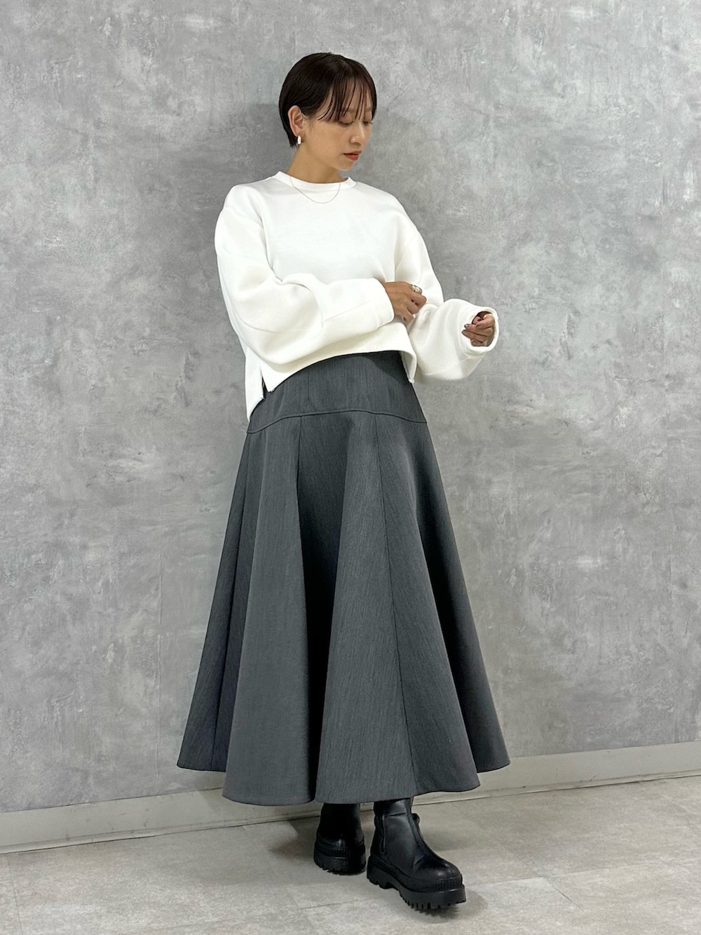 ホワイト系のTシャツ/カットソー、グレー系のスカートを着用したレディースの秋コーディネートの2枚目の写真