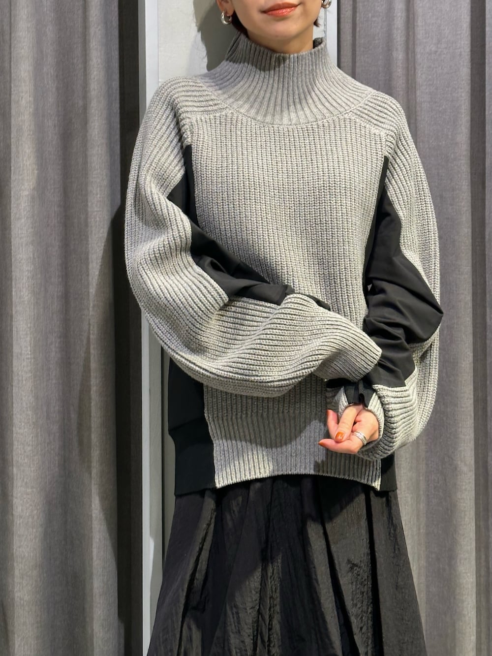 ブラック系のブーツ、ブラック系のスカート、グレー系のニット/セーターを着用したレディースの秋コーディネートの6枚目の写真