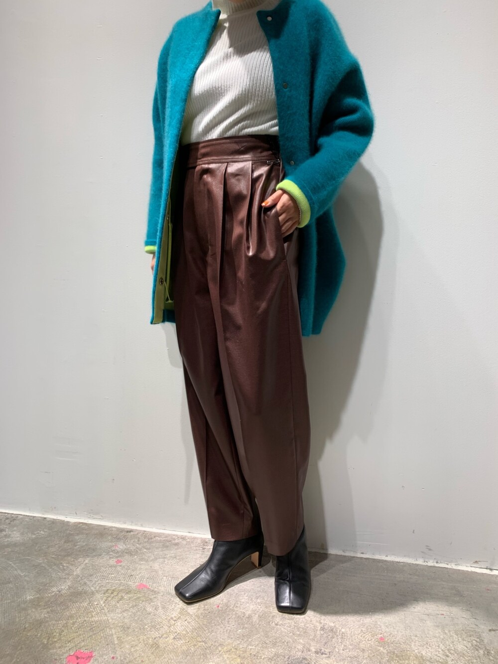グリーン系のカーディガン/ボレロ、ブラウン系のその他パンツ、ブラック系のブーツを着用したレディースの秋コーディネートの5枚目の写真