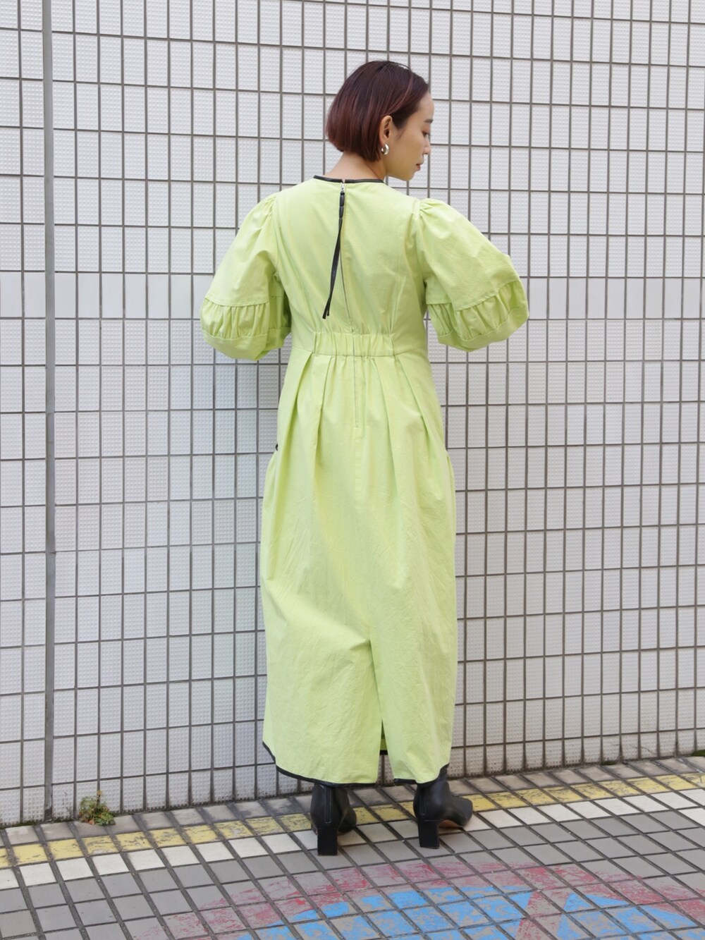 ブラック系のブーツ、グリーン系のワンピース、グリーン系のワンピースを着用したレディースの冬コーディネートの3枚目の写真