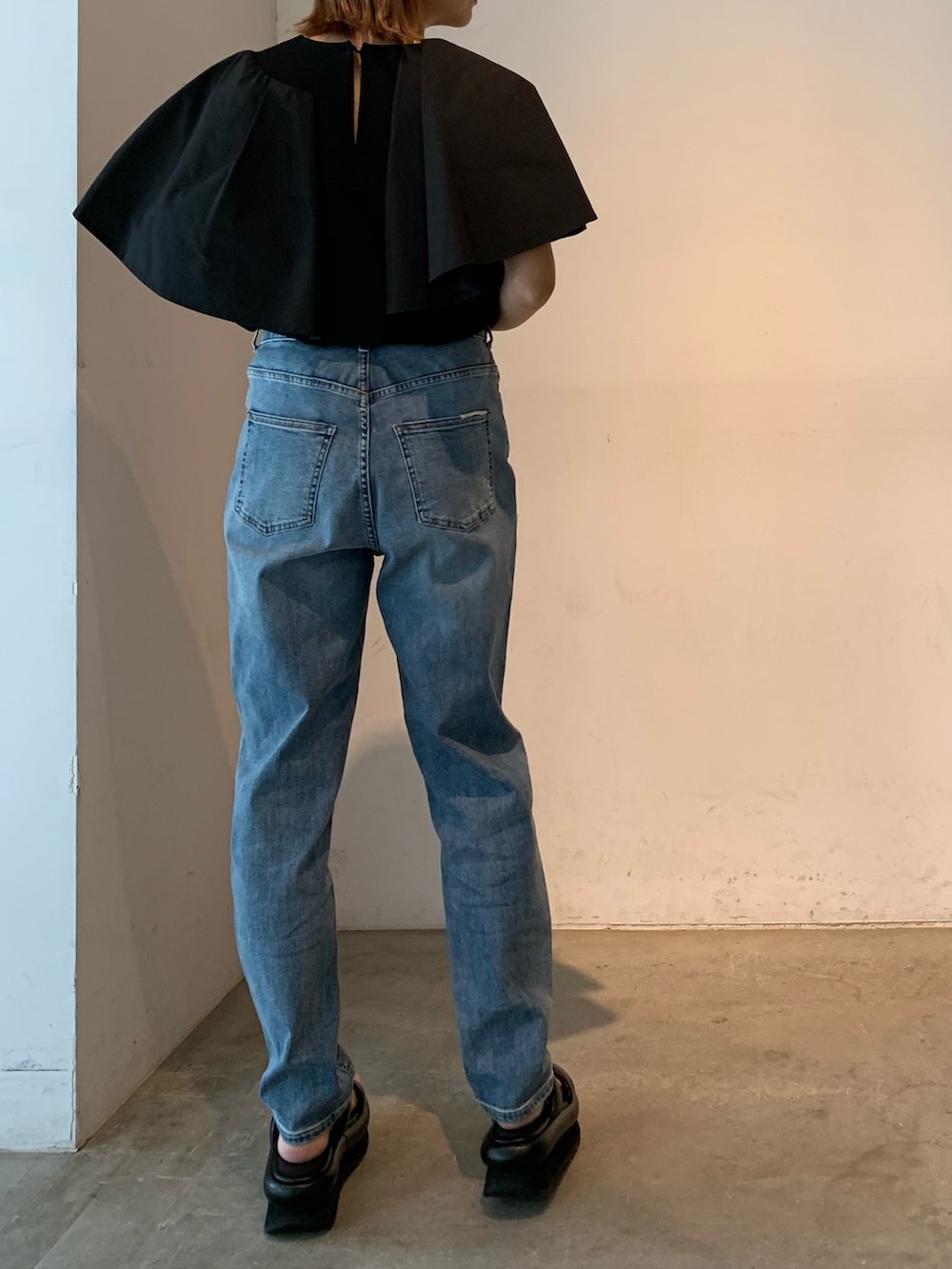 ブラック系のTシャツ/カットソー、ブルー系のデニムパンツ、ブラック系のサンダルを着用したレディースの春コーディネートの4枚目の写真