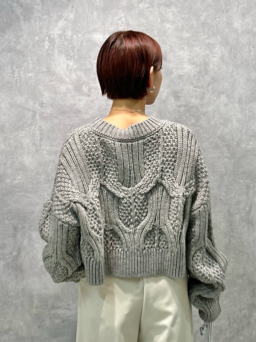 グレー系のニット/セーター、ホワイト系のその他パンツ、ブラック系のブーツを着用したレディースの秋コーディネートの7枚目の写真