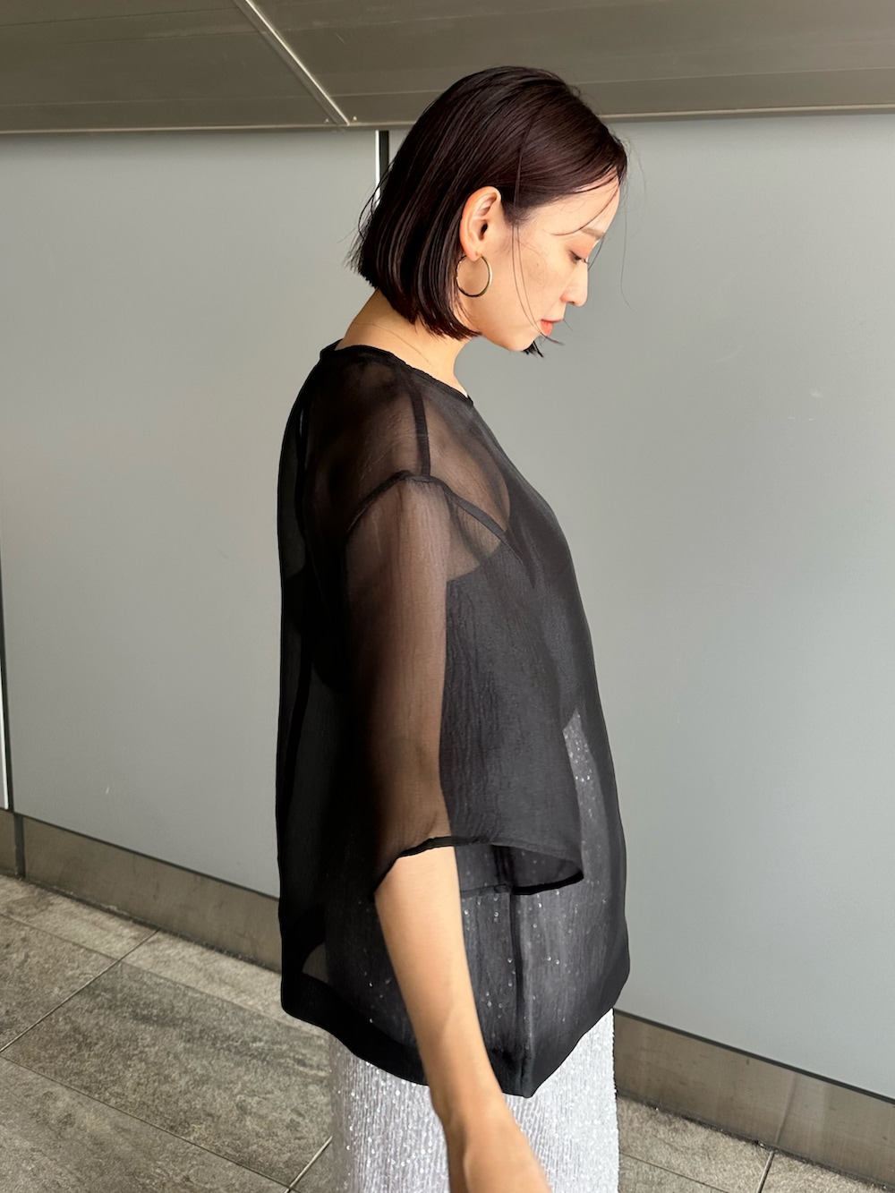 ブラック系のシャツ/ブラウス、シルバー系のスカートを着用したレディースの夏コーディネートの6枚目の写真