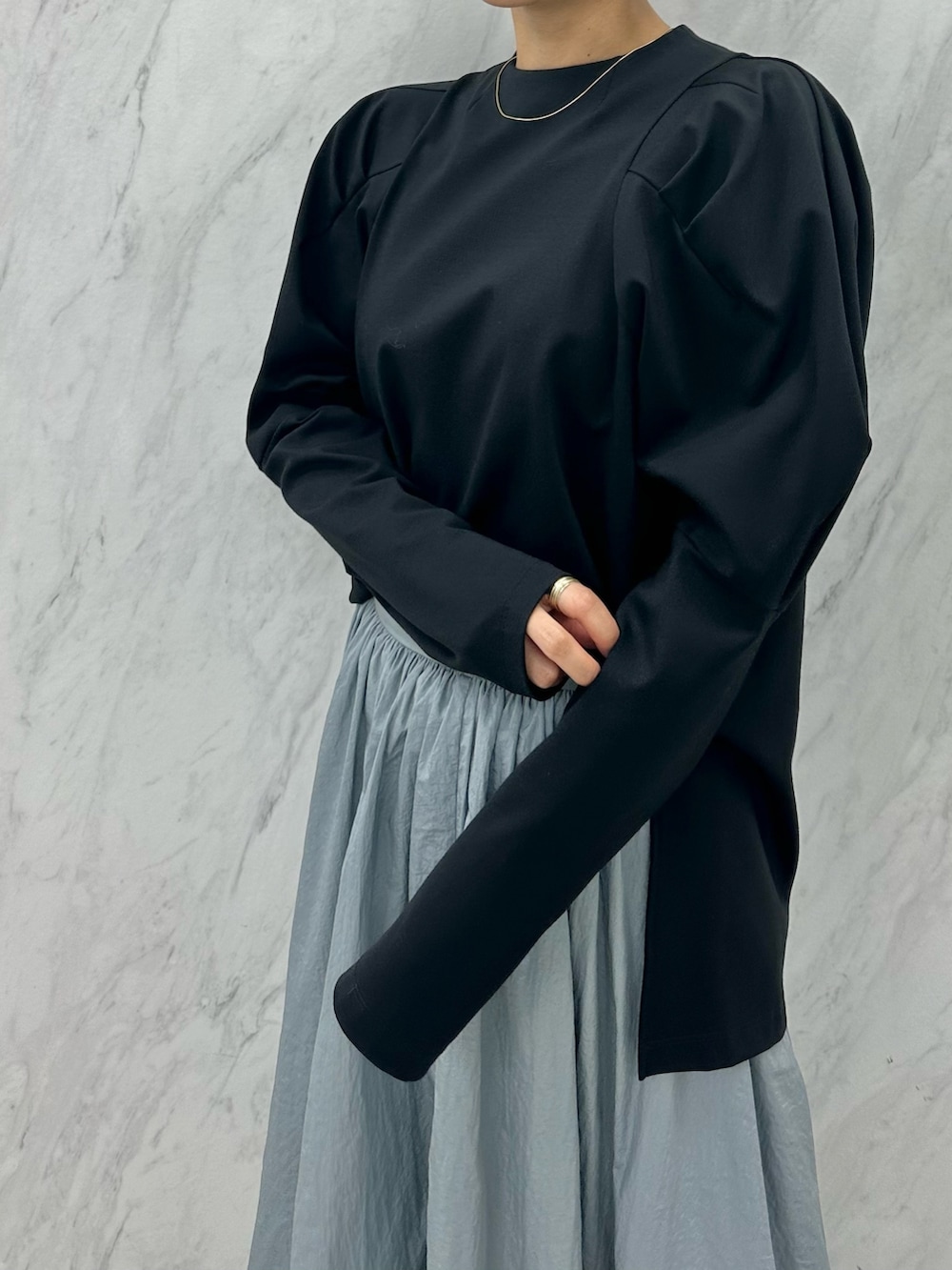 ブルー系のスカート、ブラック系のTシャツ/カットソー、ブラック系のブーツを着用したレディースの秋コーディネートの7枚目の写真
