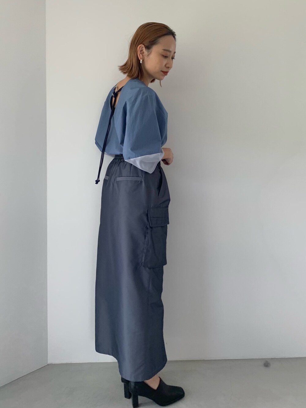 ブラック系のパンプス、ブルー系のスカート、ブルー系のシャツ/ブラウスを着用したレディースの春コーディネートの4枚目の写真