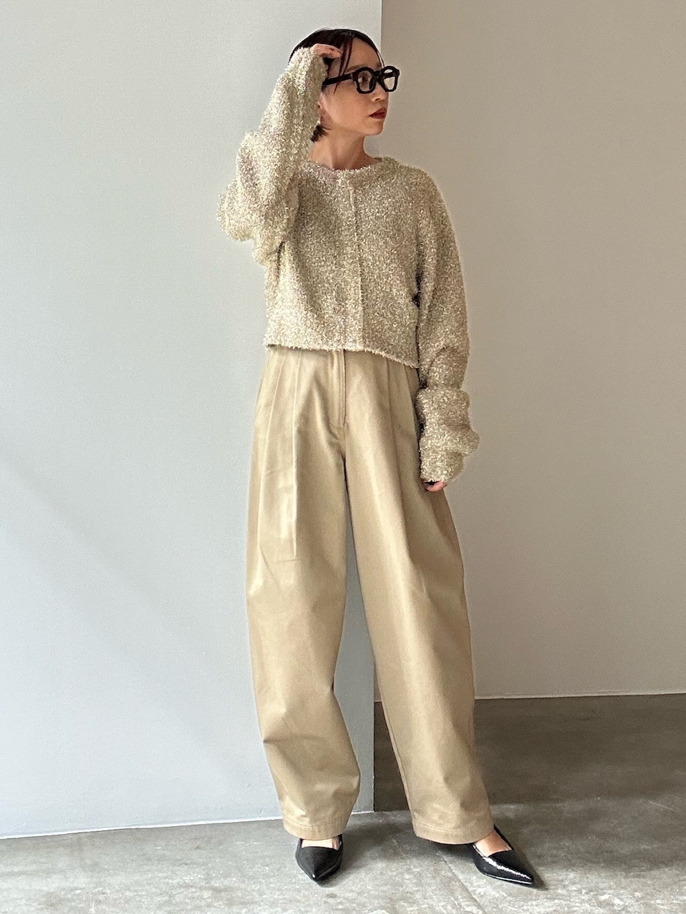 ゴールド系のカーディガン/ボレロ、ベージュ系のその他パンツ、ブラック系のサンダルを着用したレディースの冬コーディネートの6枚目の写真