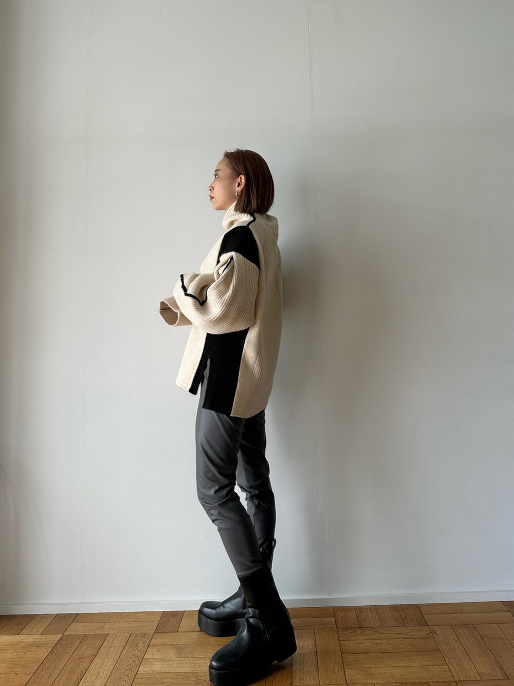 ホワイト系のニット/セーター、グレー系のその他パンツ、ブラック系のブーツを着用したレディースの秋コーディネートの5枚目の写真