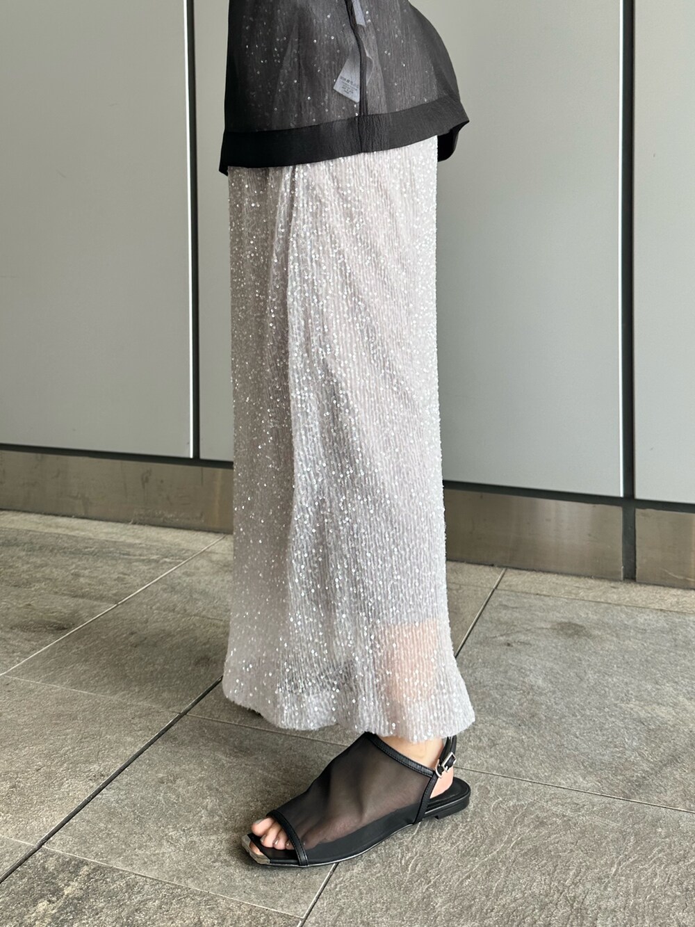 ブラック系のシャツ/ブラウス、シルバー系のスカートを着用したレディースの夏コーディネートの8枚目の写真